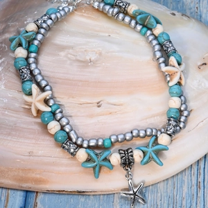 Detail of bohemian layered anklet with turquoise beads and silver starfish charms