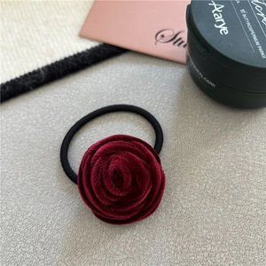 Detailed view of handmade dark red velvet rose hair tie with elastic black band