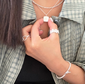 Detail of 925 sterling silver braided ring and necklace set with Paris engraving