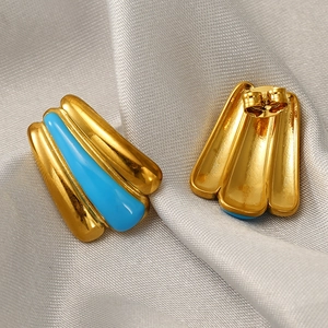 Macro detail of 18k gold plated curved stud earrings with turquoise blue enamel inlay