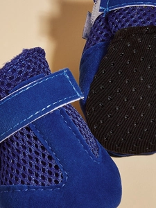 Detailed macro view of blue mesh dog shoes featuring breathable fabric and anti-slip sole