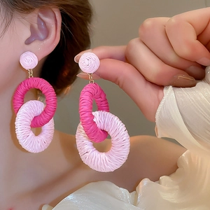 Detail of pink chiffon flower fringe earrings with interlocking circles on model