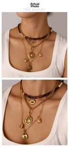 Details von mehrlagigen Goldketten mit Evil Eye und Türkis-Herzanhängern an einem Model