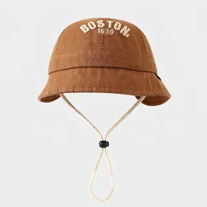 Detalle de gorro de sol para bebé con bordado Boston blanco y barboquejo ajustable