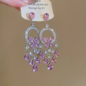Close-up of pink zircon butterfly tassel earrings with silver needles and sparkly crystals