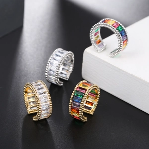 Detail of adjustable gold and silver rings set with colorful rectangular zircons