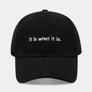 Dettaglio cappello da baseball in velluto nero con ricamo bianco 'it is what it is'