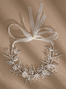 Detailed view of silver floral bridal headband with rhinestones and white silk ribbons