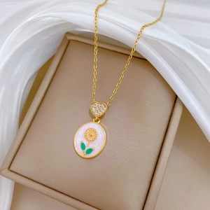 Gold heart necklace with crystal sunflower enamel pendant on a jewelry display stand