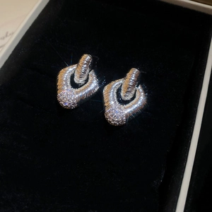 Dettaglio di orecchini a cerchio intrecciati in argento con pavé di micro diamanti