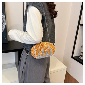 Detail of orange and silver rhinestone clutch bag with corn texture and chain strap