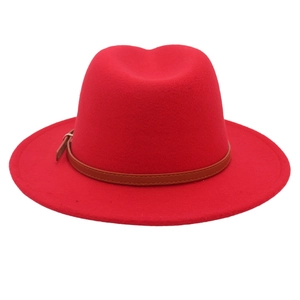 Close-up of red fedora hat with brown leather belt buckle and gold metal hardware