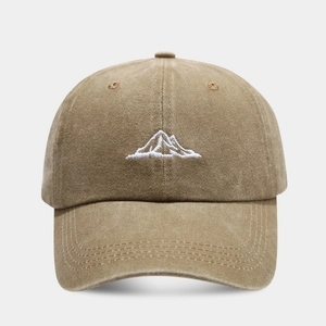 Close-up of mountain embroidery and washed cotton texture on khaki baseball cap