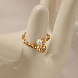 Bague irrégulière dorée avec perle blanche sur main en céramique bijou élégant