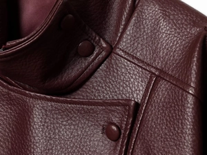 Gros plan sur le cuir PU grainé bordeaux avec détail de bouton-pression assorti