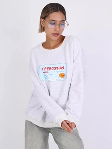 Nahaufnahme des hellgrauen Sweatshirts mit Rundhalsausschnitt und russischem Buchstabendruck