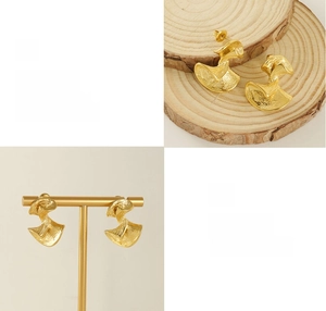 Close-up of golden fan-shaped irregular earrings with polished mirror finish and textures