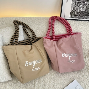 Detail of cute dog plush tote bags in khaki and pink colors with striped handles