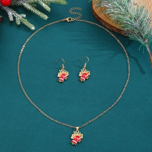 Detailaufnahme des Weihnachts-Schmucksets mit roten Glocken und grünen Blättern auf Tannengrün