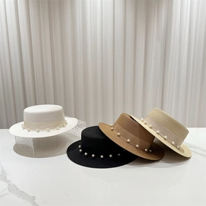 Détail de quatre chapeaux canotiers en paille avec ruban élégant et perles