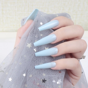 Detail of light blue glossy long coffin press-on nails on a hand with star mesh