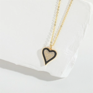 Detailed close-up of a heart-shaped necklace with black enamel and white pavé stones