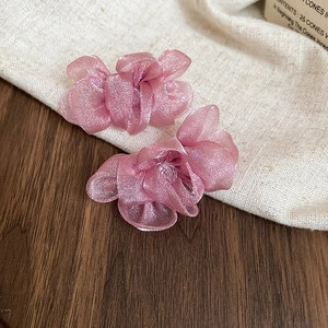 Close-up of pink chiffon flower earrings featuring multi-layered translucent petals