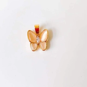 Detail of 18k gold butterfly pendant with pink cat eye stone wings and zircon center