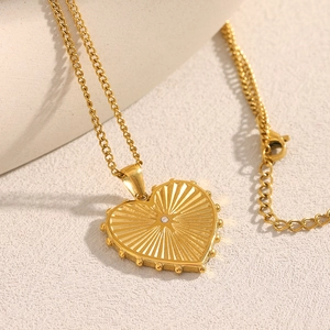 Detail of 18K gold plated heart pendant with radial texture and central small diamond