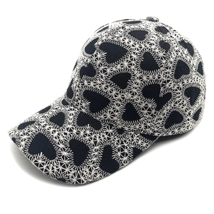 Classic black baseball cap with white heart embroidery and curved brim in side view