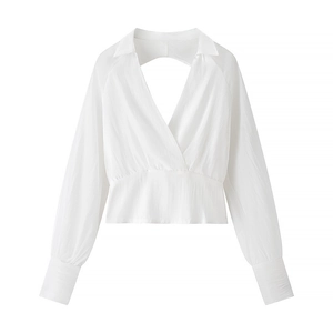 Detail of white long sleeve top with deep V-neck and textured pleated fabric design