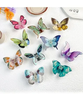 Detailed top view of 10 colorful acrylic butterfly hair claws on a white textured background