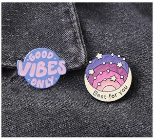 Close-up of enamel pins featuring Good Vibes Only and Best For You text on denim jacket