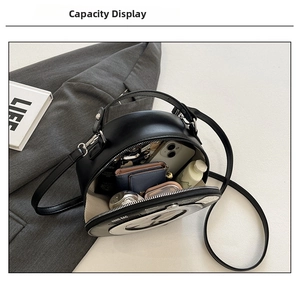 Interior view of circular crossbody bag showing phone, wallet and cosmetics capacity