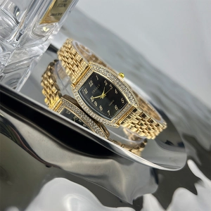 Macro detail of tonneau emerald-cut quartz watch with gold metal band and crystal bezel