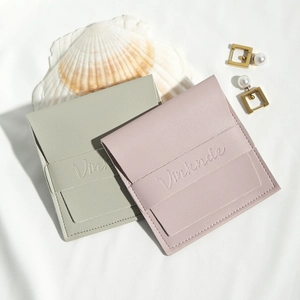 Minimalist PU leather jewelry gift pouches in soft pink and sage green with snap buttons