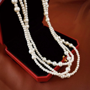 Close-up of elegant multi-layer white pearl necklace displayed in a red jewelry gift box