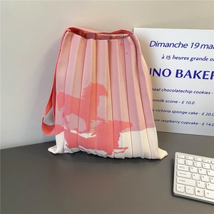 Detail of pink and white pleated knit tote bag with vertical accordion texture and patterns