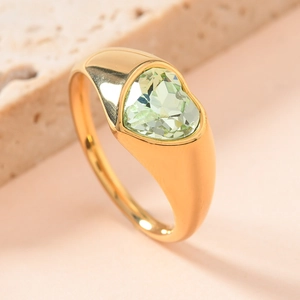 Macro shot of gold stainless steel ring featuring a heart-shaped green gemstone inlay