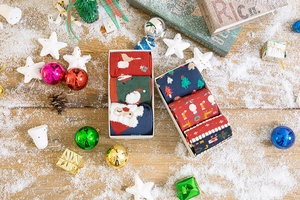 Close-up of festive Christmas gift box set featuring red and green elk pattern crew socks