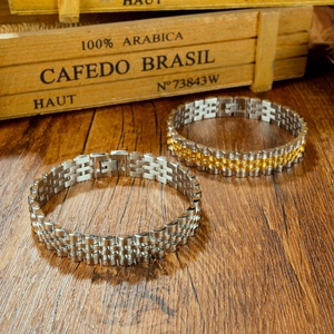 Classic silver and bicolor gold titanium steel watch band bracelets on a wooden surface