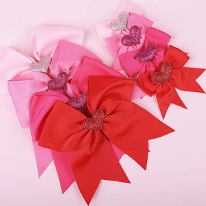 Detail of five pink and red grosgrain ribbon hair bows with glittery hearts for girls