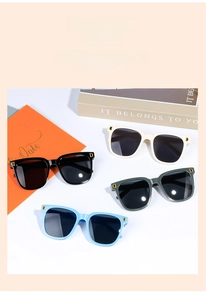 Détail de quatre lunettes de soleil enfant avec logo D doré sur les branches
