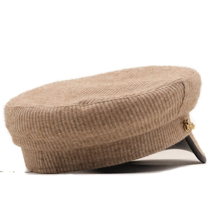 Detail of khaki knit baker boy hat with gold chain accent and black leather brim