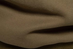 Macro shot of khaki cotton blend fabric texture showing soft weave and material thickness