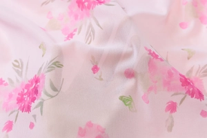 Dettaglio del tessuto in mesh rosa trasparente con stampe floreali e motivi a farfalla