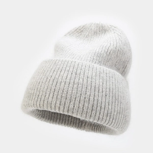 Close-up of light gray angora rabbit fur beanie with ribbed knit texture and wide folded brim