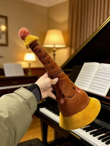 Close-up of a suona flute plush toy with a cute face held in a warm musical setting