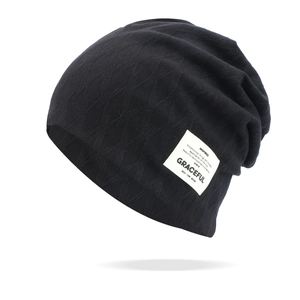 Detail of black knitted beanie showing diamond texture and white Graceful woven label
