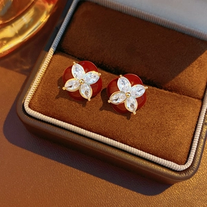 Detailed macro of red flower stud earrings with crystals in a brown velvet jewelry box